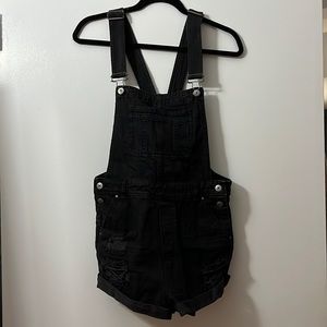 black denim short overalls. Ripped details on front pockets. Size 6